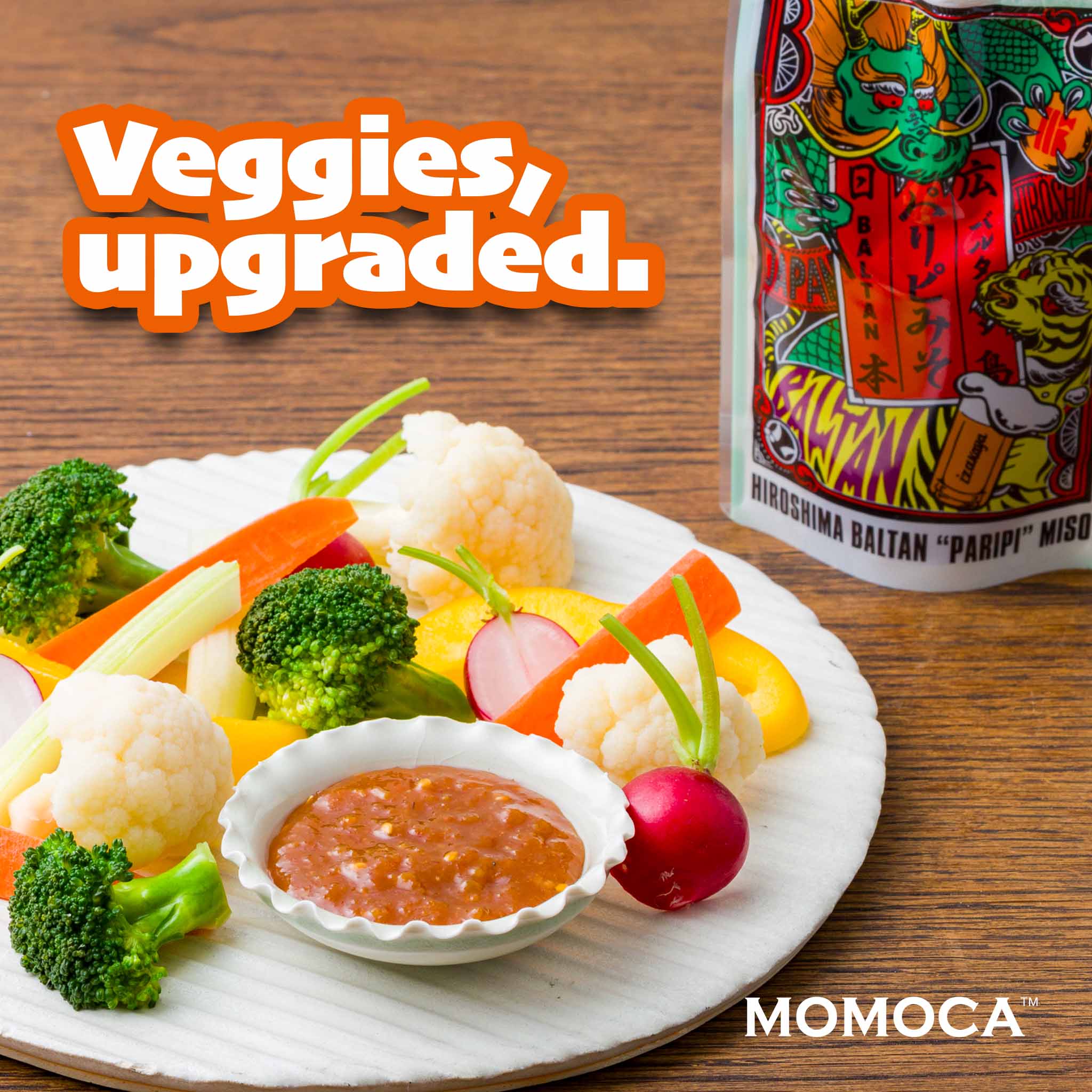 Assorted vegetables on a plate with a bowl of dipping sauce, featuring the brand 'MomoCA'.