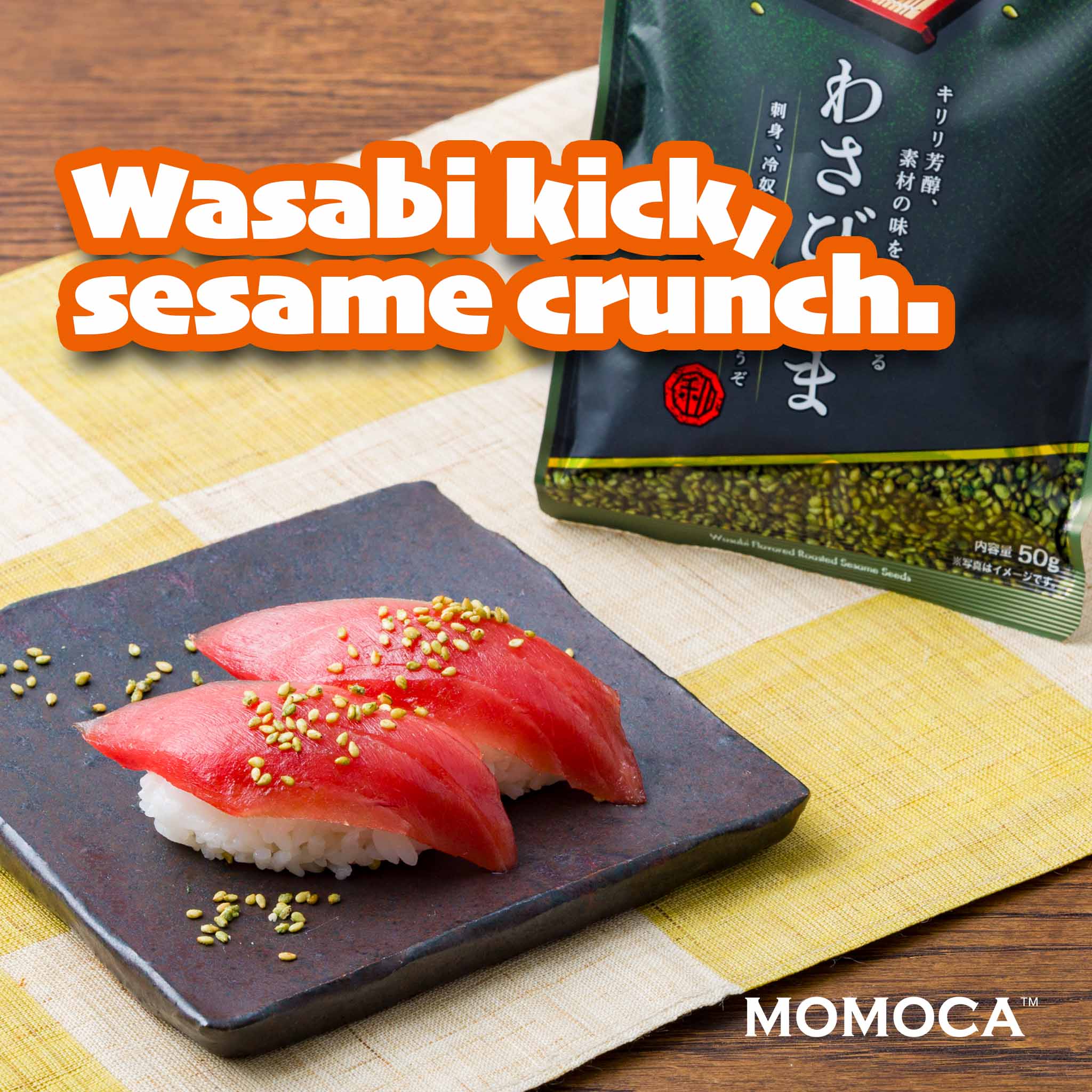 Sushi with wasabi and sesame seeds on a black plate, next to a package labeled 'Wasabi kick sesame crunch' by MOMOCA.