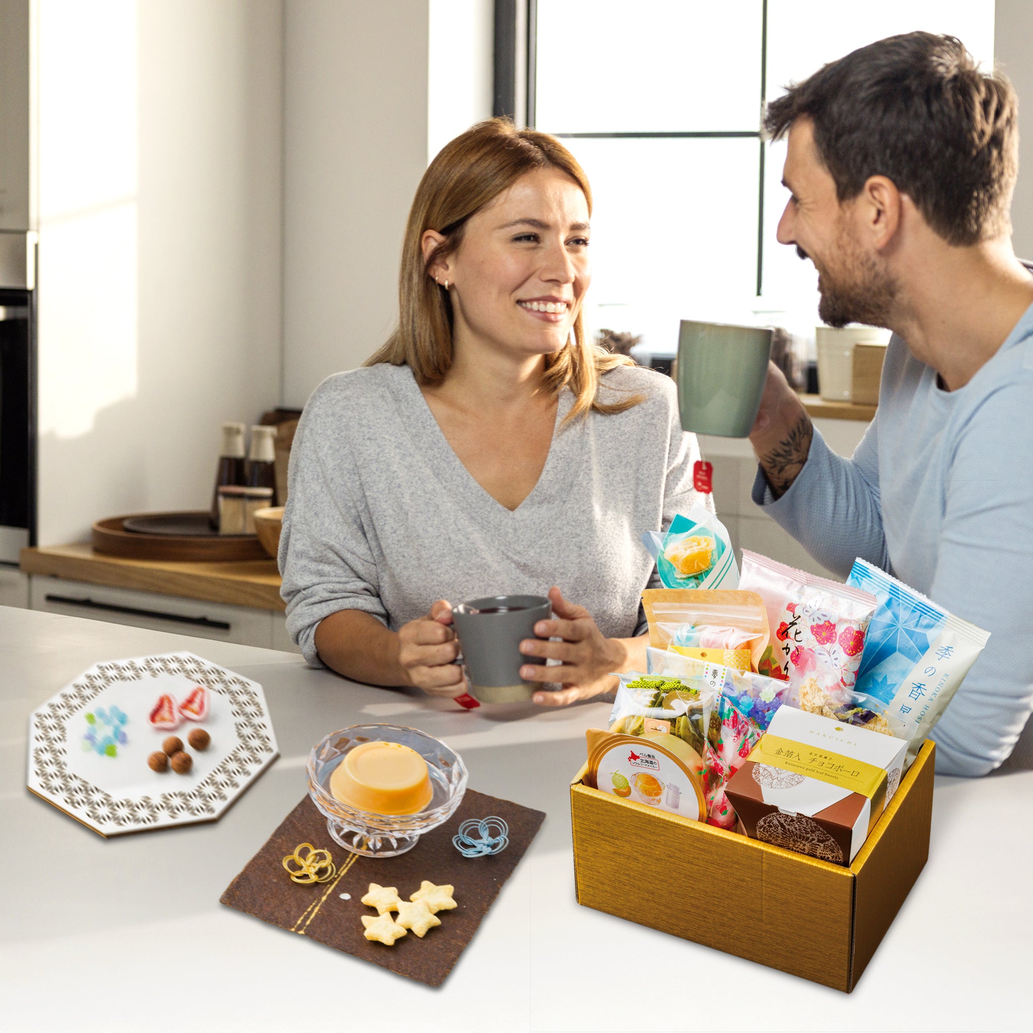 Man and woman sitting at a table with snacks and drinks, smiling and enjoying each other's company.