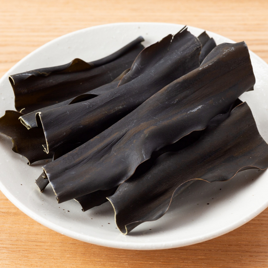 An authentic plate of black seaweed, a popular Japanese snack, beautifully presented on a wooden table.