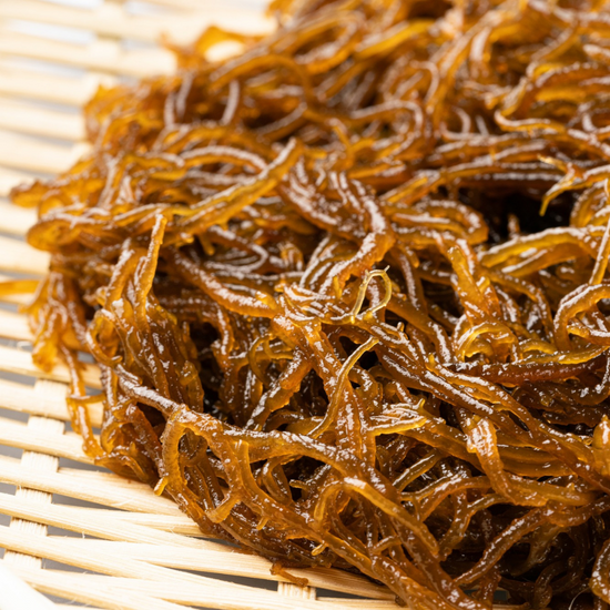 An authentic bowl of seaweed, a popular ingredient in Japanese snacks, sitting on top of a wooden table.