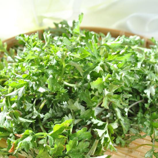 Fresh parsley in a wooden bowl on a table.