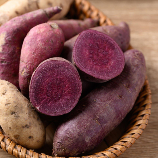 Authentic Japanese snacks - purple sweet potatoes in a basket on a wooden table.
