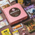 An open Momoca Wellness Welcome Snack Box filled with curated Japanese snacks, displayed on a beige background.