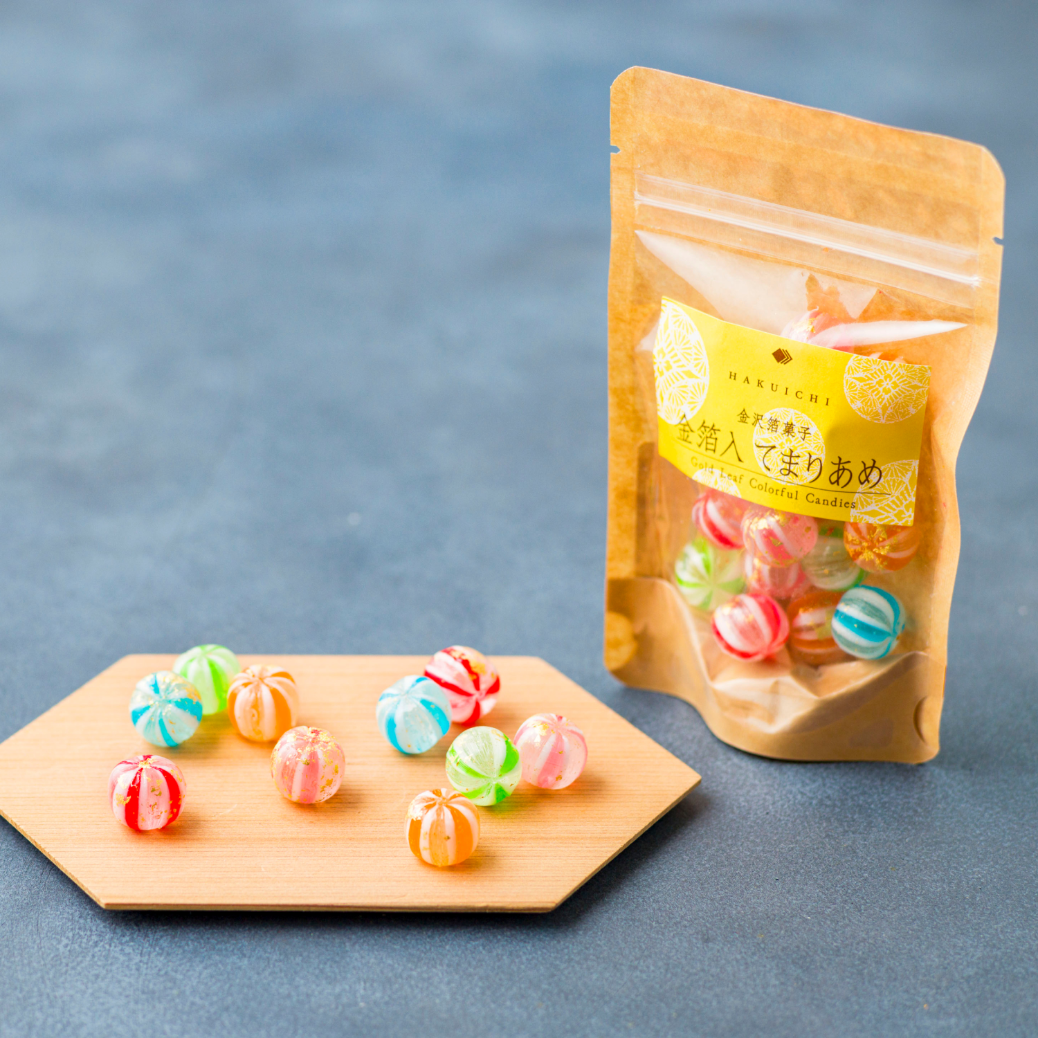 Packaged gummy candies on a wooden board with a blue background